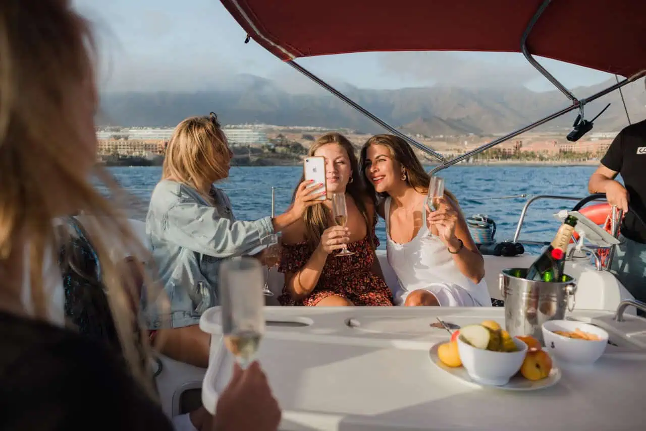 Guests on the Atlantic Star capturing a selfie, with smiles and glasses raised, cherishing the moment against a scenic ocean backdrop.