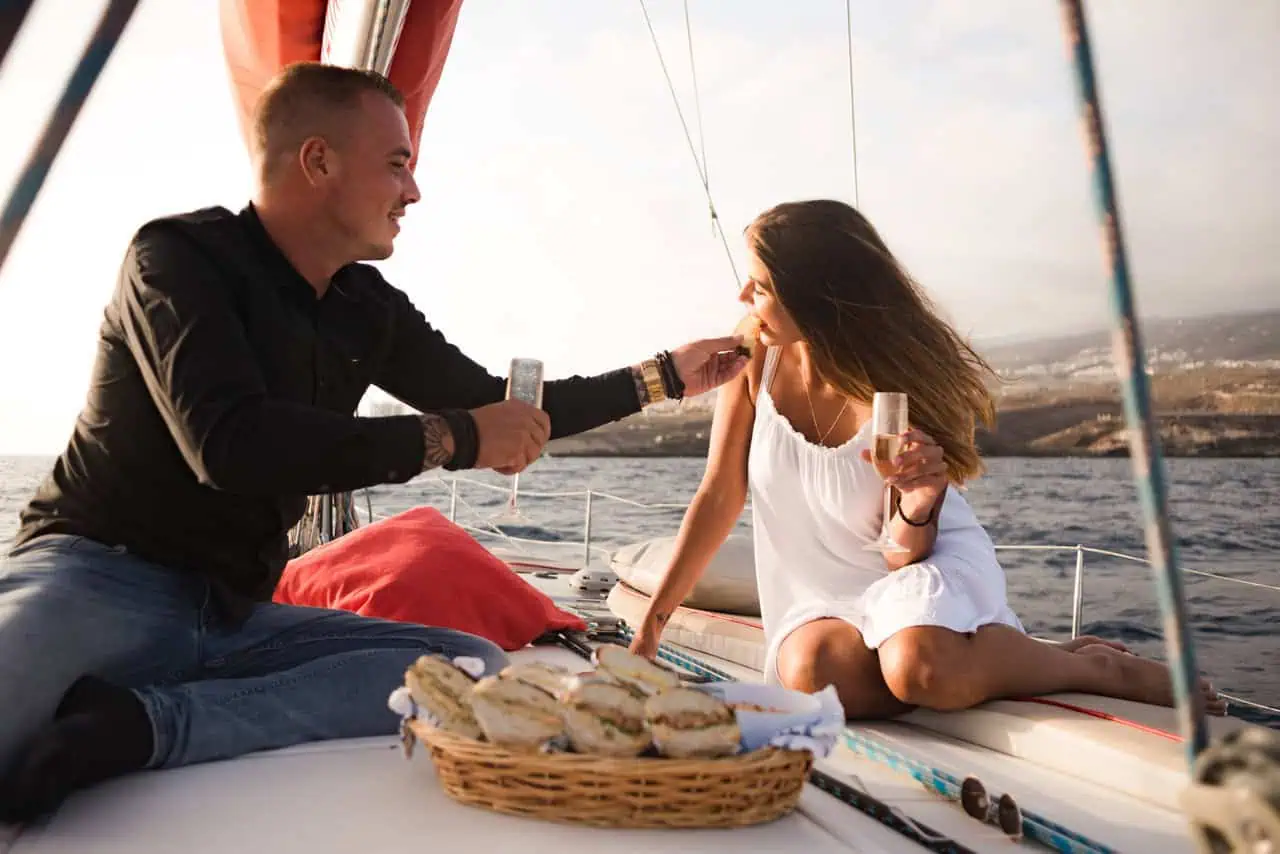 A couple shares a romantic moment over a meal aboard a sunset cruise in Tenerife, exemplifying an ideal romantic outing.