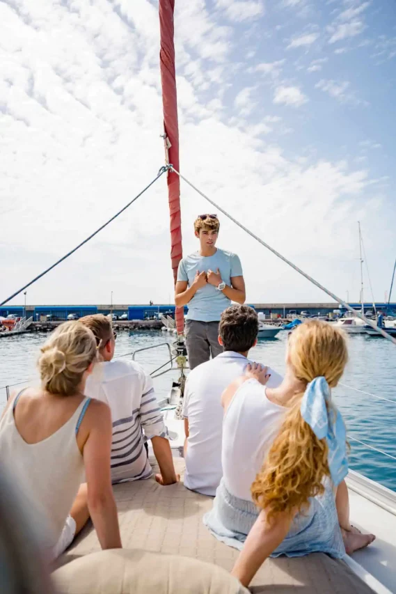 Passengers attentively listening to a guide aboard the Atlantic Star yacht as he explains safety protocols and tour guidelines before departing from Puerto Colon, Tenerife, ensuring a secure and enjoyable experience for everyone on board.