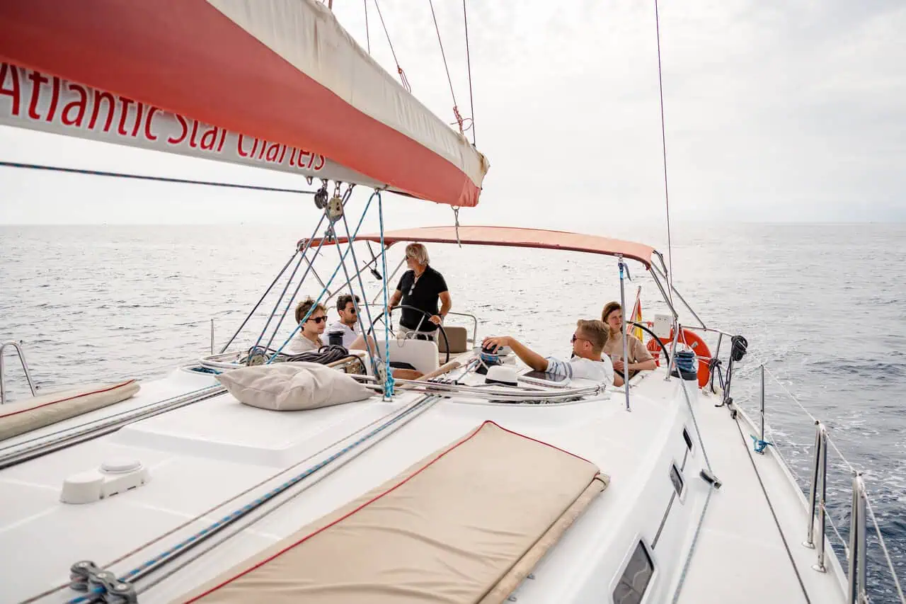 Passengers on the Atlantic Star enjoying panoramic views of the Tenerife coastline from the boat's forward deck.