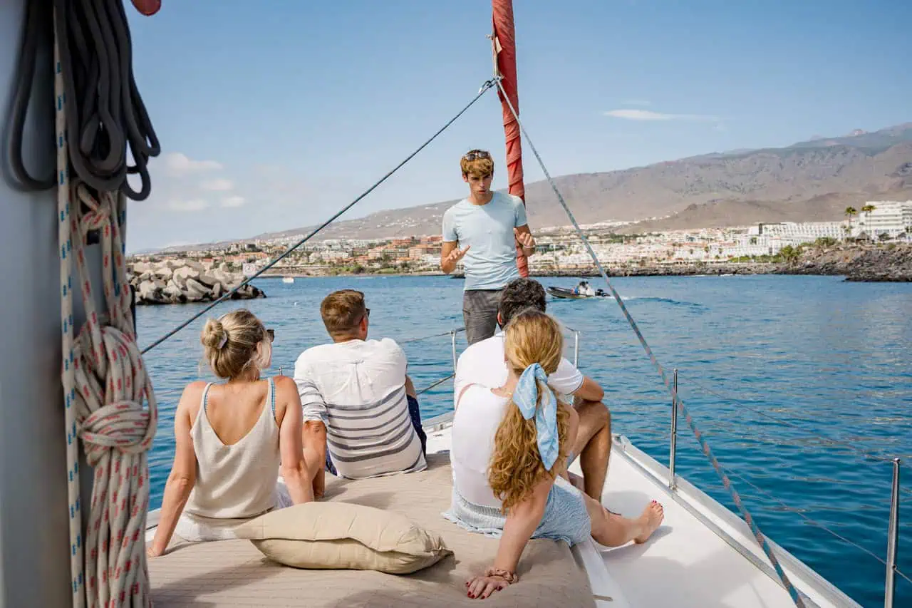 A group enjoys their time together on the Atlantic Star, with laughter and drinks, epitomizing the joy of shared sea adventures.